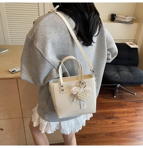 Détail du sac cabas plissé tendance avec pendentif cœur en perles et bandoulière réglable