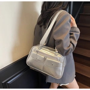 Detail of silver metallic bowling bag featuring dual front flap pockets and hardware