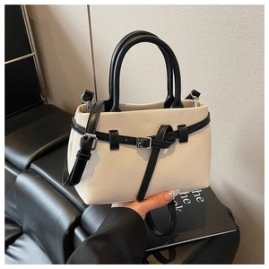 Close-up of contrast bucket bag featuring textured canvas and black leather strap details
