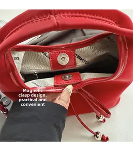 Détail du sac en cuir rouge montrant le fermoir magnétique et la doublure imprimée