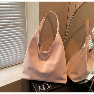 Detail of glossy pink patent leather tote bag with elegant side lighting and reflections