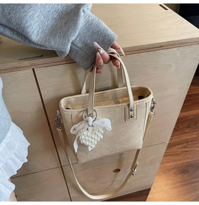 Vue détaillée du sac seau crème avec pendentif cœur en perles et nœud en dentelle