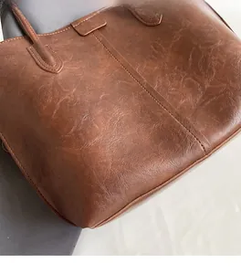 Close-up of high-quality brown lychee grain leather texture and durable reinforced stitching