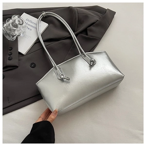 Detailed view of silver metallic PU leather tote bag with unique knot shoulder strap details