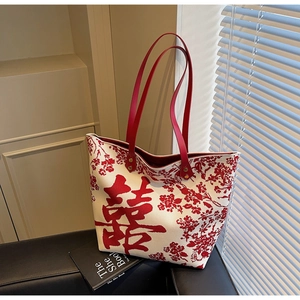 Detail of red floral canvas tote bag with traditional Xi character and leather straps