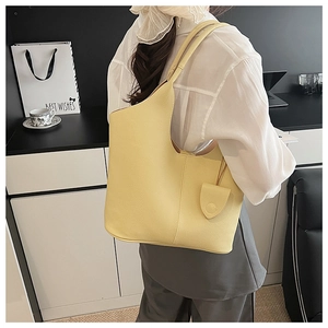 Detail of soft yellow faux leather tote with textured litchi pattern and hanging pouch