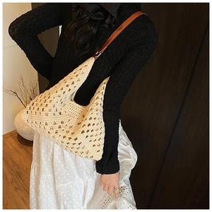 Détail d'un sac à bandoulière en maille ajourée beige avec bandoulière en cuir marron