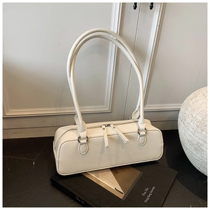 Detail view of white minimalist baguette bag with dual zippers and smooth leather texture