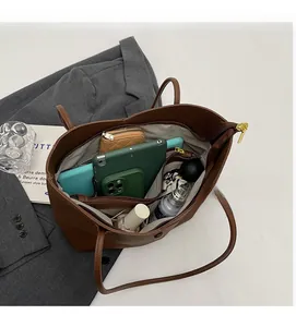 Macro view showing the spacious multi-pocket interior of the brown leather tote bag