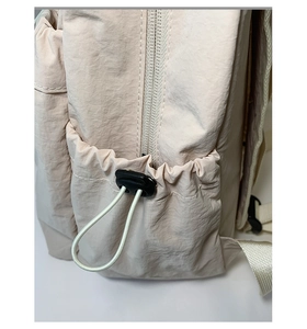 Close-up of lightweight nylon backpack side pocket with adjustable drawstring and toggle