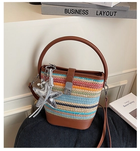 Detail of multi-color woven bucket bag with leather base and starfish charm