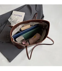 Spacious interior of dark brown tote bag holding a tablet, umbrella, and long wallet