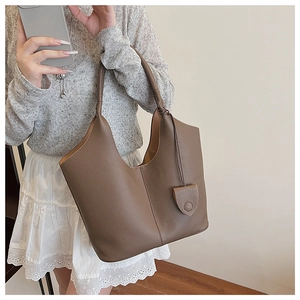 Detail shot of the large textured leather bucket bag with a unique knot handle design