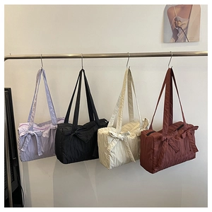 Detailed view of four pleated nylon bucket bags in lilac, black, cream, and brown colors