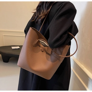 Shoulder view of a brown large capacity tote bag with lychee texture for office commute