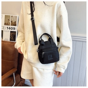 Lifestyle shot of a black waterproof nylon crossbody bag with adjustable strap and handles