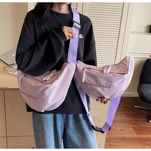 Detail of canvas crescent bags in lavender and pink with woven zipper pullers