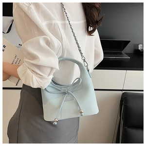 Détail d'un sac à main en cuir bleu clair avec nœud 3D et élégante bandoulière