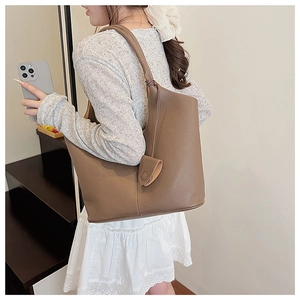 Detailed close-up of brown soft leather hobo bag with unique knotted strap and pebble texture