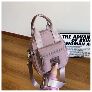 Detail view of pink waterproof nylon crossbody bag with top handle and adjustable strap
