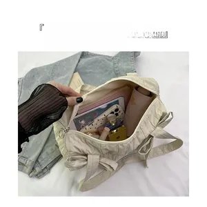 Spacious interior of beige quilted tote bag holding tablet, umbrella and cosmetics
