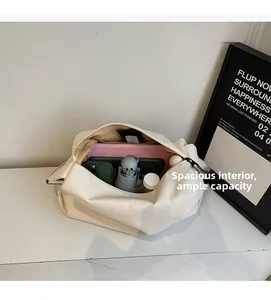 Spacious interior of the beige canvas tote bag holding a tablet, phone, and water bottle