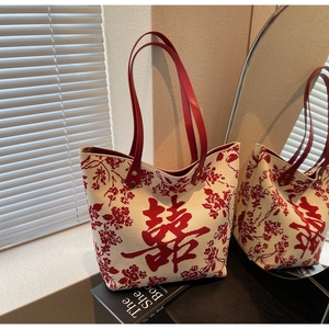 Detail of red Xi character on a cream tote bag with floral patterns for weddings