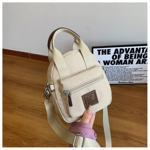 Close-up of a mini beige waterproof nylon crossbody bag with leather logo detail
