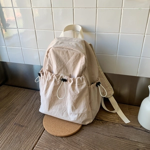 Detail of nylon backpack featuring adjustable drawstring pockets and minimalist design