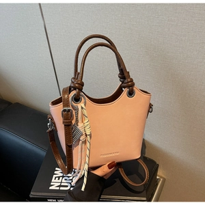 Détail du sac cabas beige clair avec anses marron foncé et gaufrage de la marque