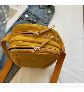 Détail du sac bandoulière en nylon jaune vif avec compartiments à double fermeture éclair