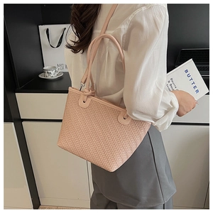 Detailed close-up of the pink woven texture and leather strap on the bucket bag