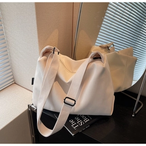Detail of hobo bag in cream corduroy fabric with wide strap and black buckle