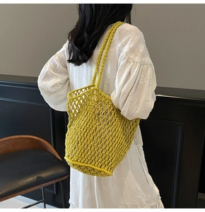 Close-up of lime green hollow knit tote bag with handmade rope weave on white floral dress