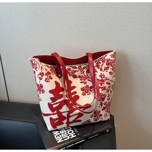 Detail of canvas wedding tote bag featuring red floral patterns and XI character