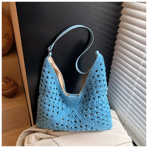 Detail of hand-woven hollow knit pattern and beige lining on sky blue shoulder bag