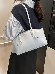Minimalist light blue tote bag for women featuring a knot buckle and sleek leather texture