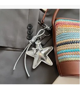 Dettaglio di ciondolo a forma di cane palloncino argento su borsa a secchiello tessuta