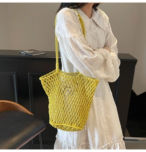 Model showing a bright yellow hollow-out knit tote bag for beach and summer vacations