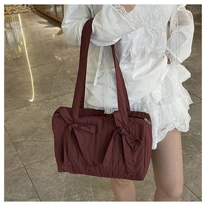 Detail showing dark red pleated nylon bucket bag with cute decorative bows and texture