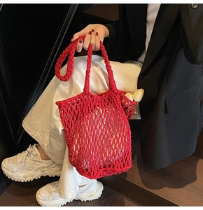Detail of red hollow crochet knit tote bag with handmade cotton rope mesh texture