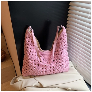 Détail du motif floral au crochet rose sur un sac à bandoulière en maille ajourée