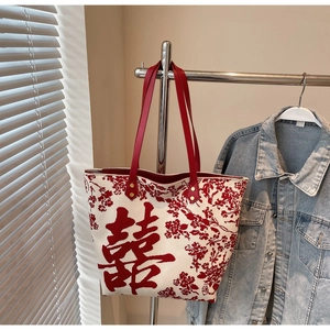 Detail of red Double Happiness character and floral embroidery on white canvas tote bag