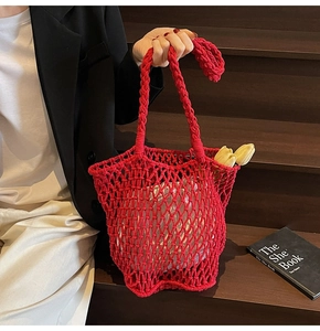 Detail of red hand-woven hollow knit tote bag with thick cotton rope and mesh structure