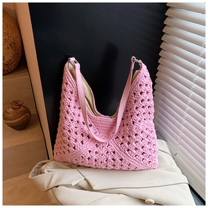 Sac hobo rose tissé main avec texture crochetée ajourée sur une veste beige