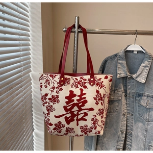 Detail of knitted wedding tote bag featuring a red Double Happiness character and flower print