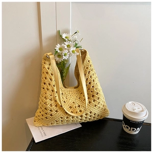 Gros plan du sac fourre-tout en crochet jaune avec textures pétales et poignée en cuir