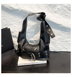 Détail du sac punk en cuir noir avec œillets argentés et fermetures éclair métalliques de luxe