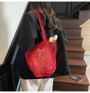 Detailed view of red hand-woven hollow tote bag with white lining and cotton rope texture