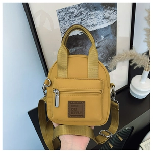 Close-up of mustard yellow waterproof nylon handbag with DAI OU STYLE logo and zip pocket
